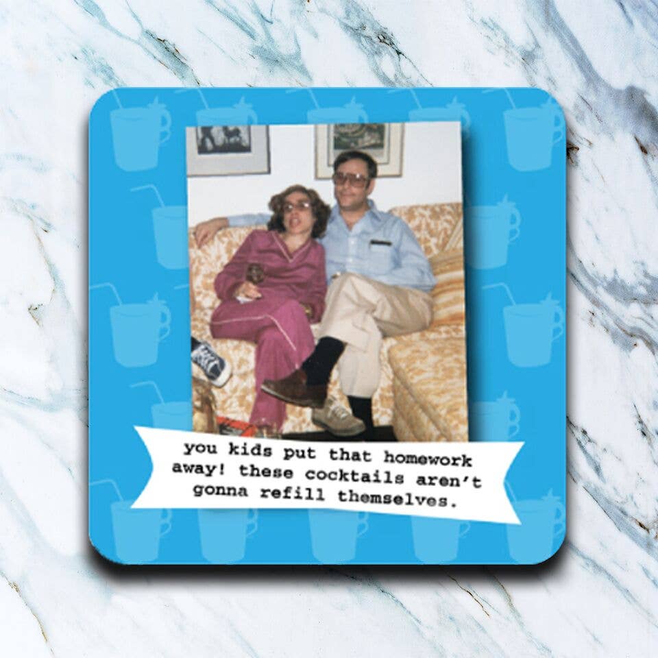 Coaster with a humorous quote and image of a couple on a couch, placed on a marble surface.