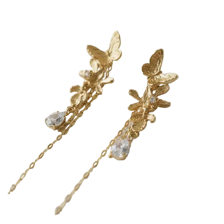 Gold butterfly earrings with chain and crystal accents on a light background
