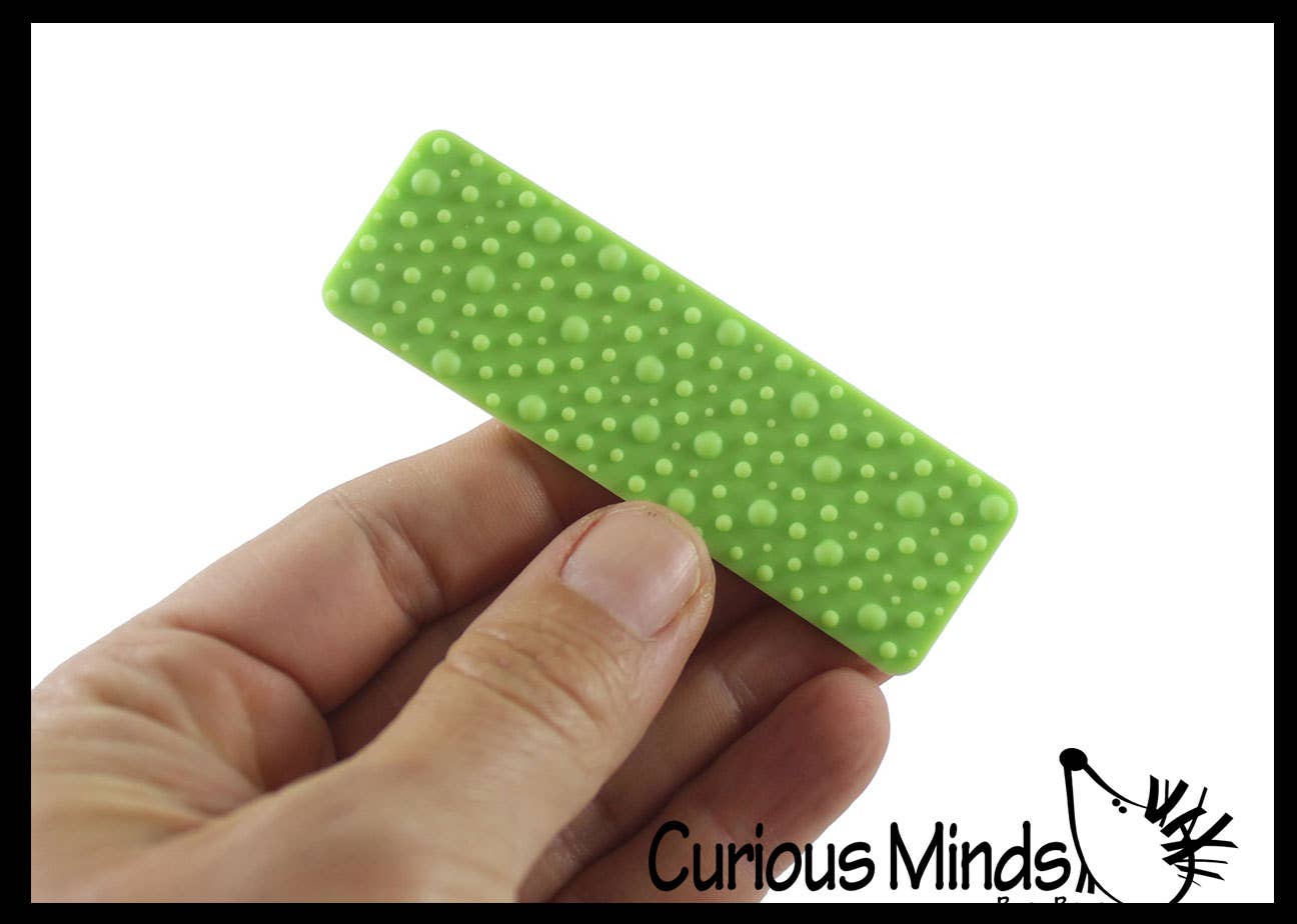 Hand holding a green textured strip with dots, branded 'Curious Minds' branding