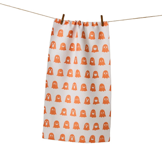 Fabric with orange ghost pattern on a white background, hanging on a clothesline.