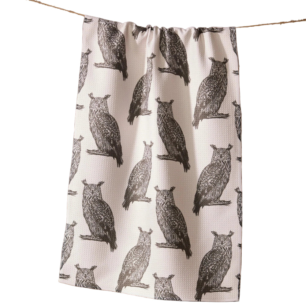 Tea towel with owl pattern hanging on a line against a white background
