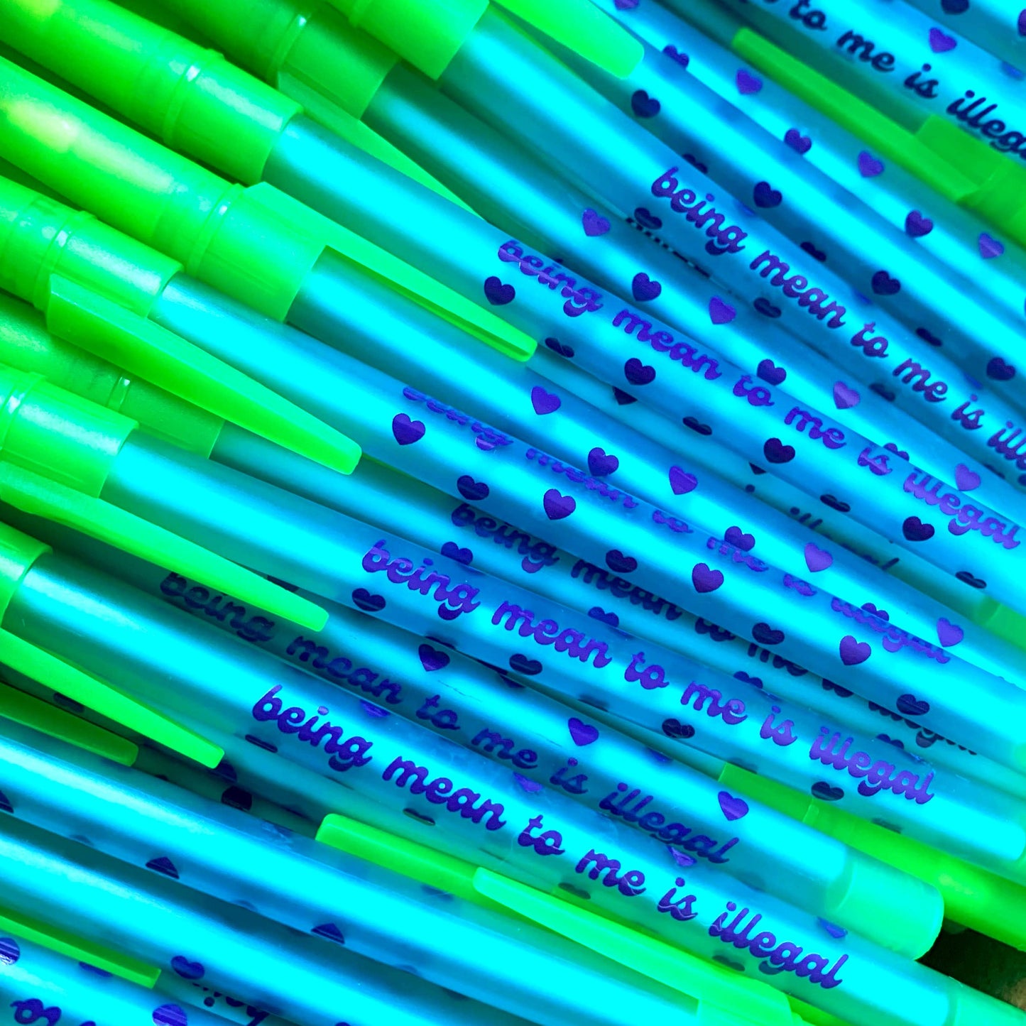 Neon green and blue pens with text and heart patterns