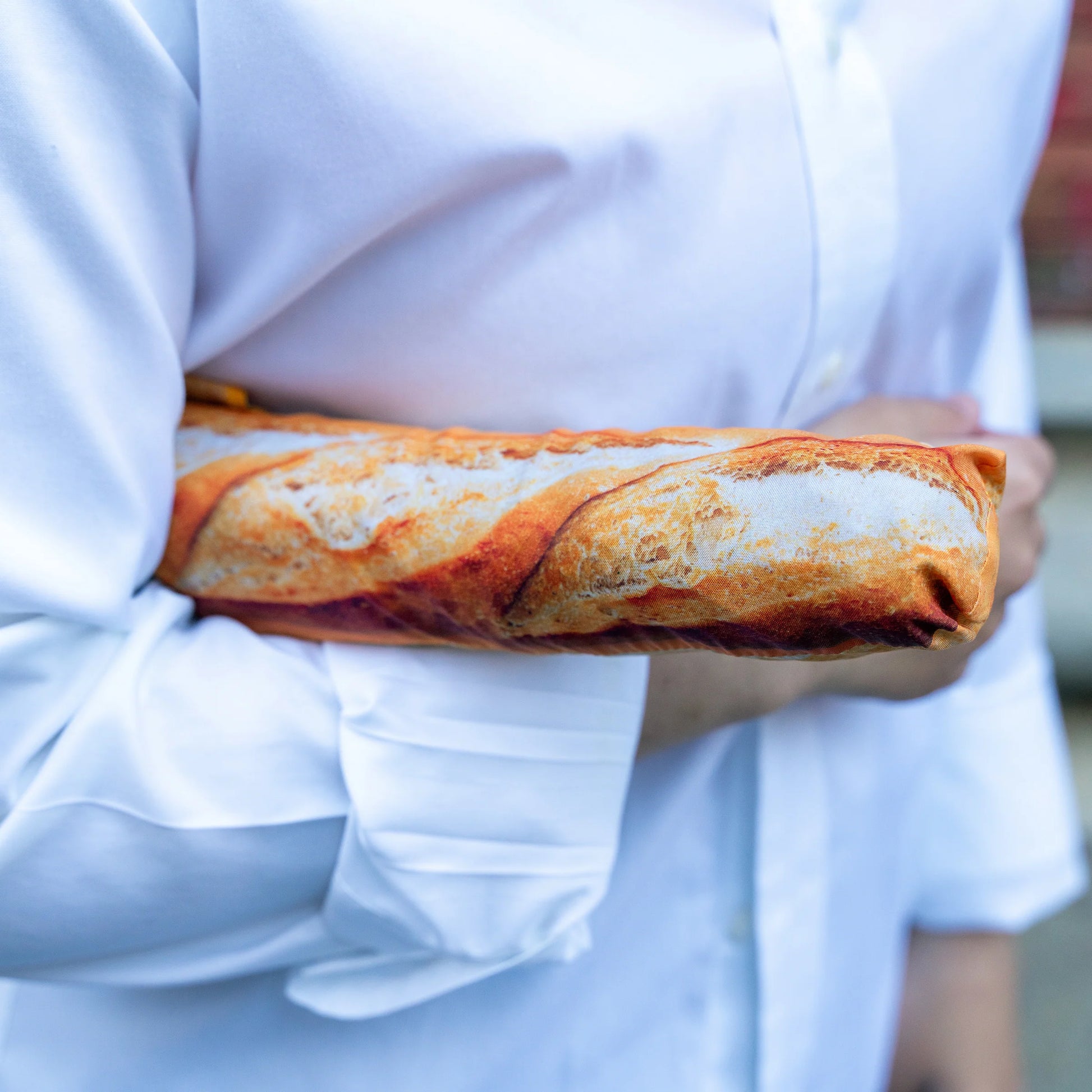 a baguette umbrella in use, looks like a baguette of bread under your arm.