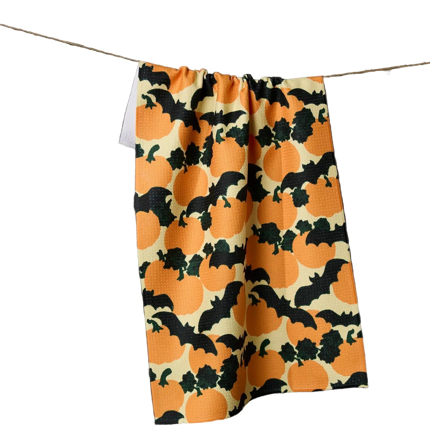 Pumpkin and bat patterned fabric hanging on a line against a white background