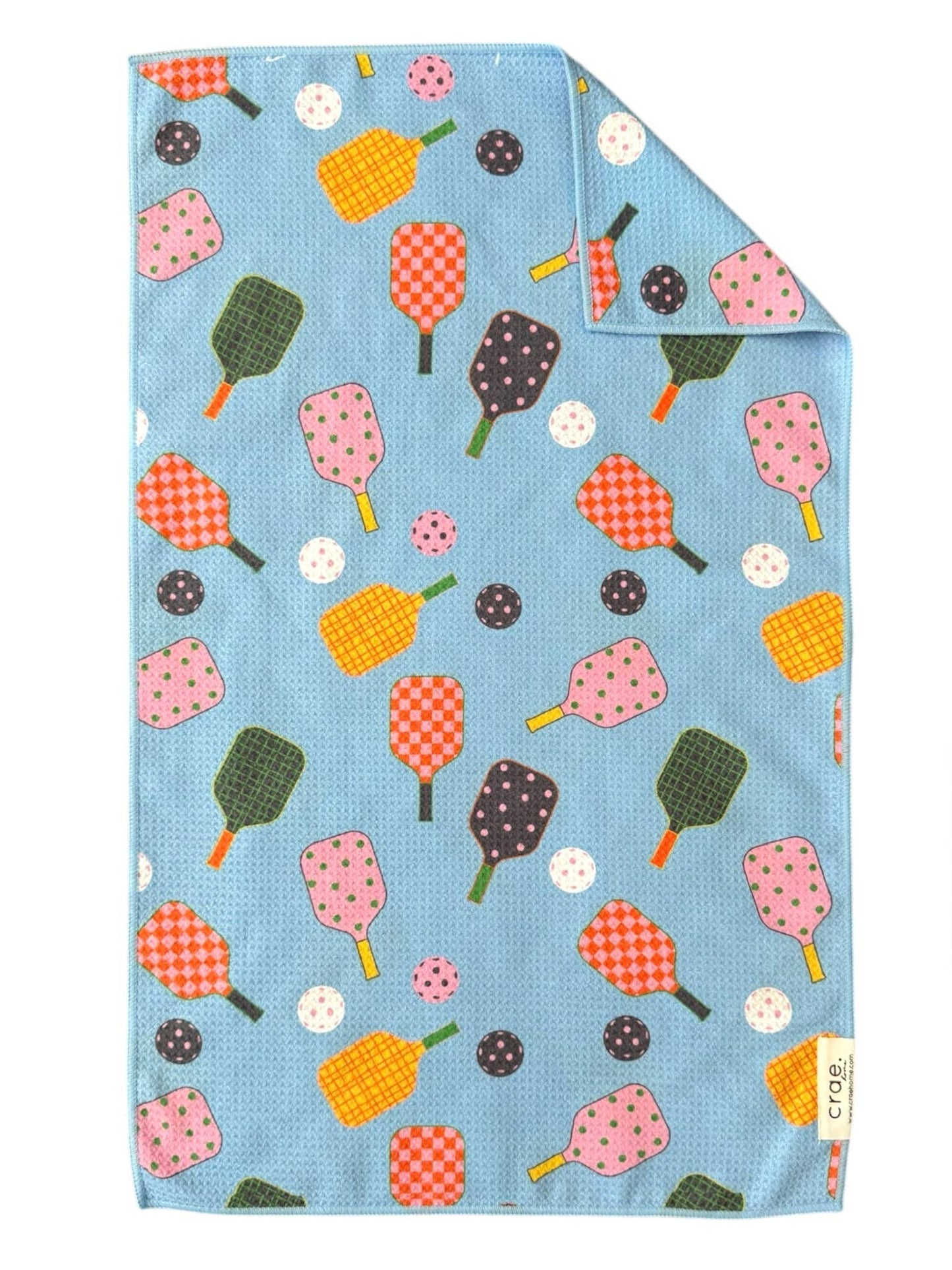 Blue tea towel with pickleball and pickleball paddle pattern on a white background