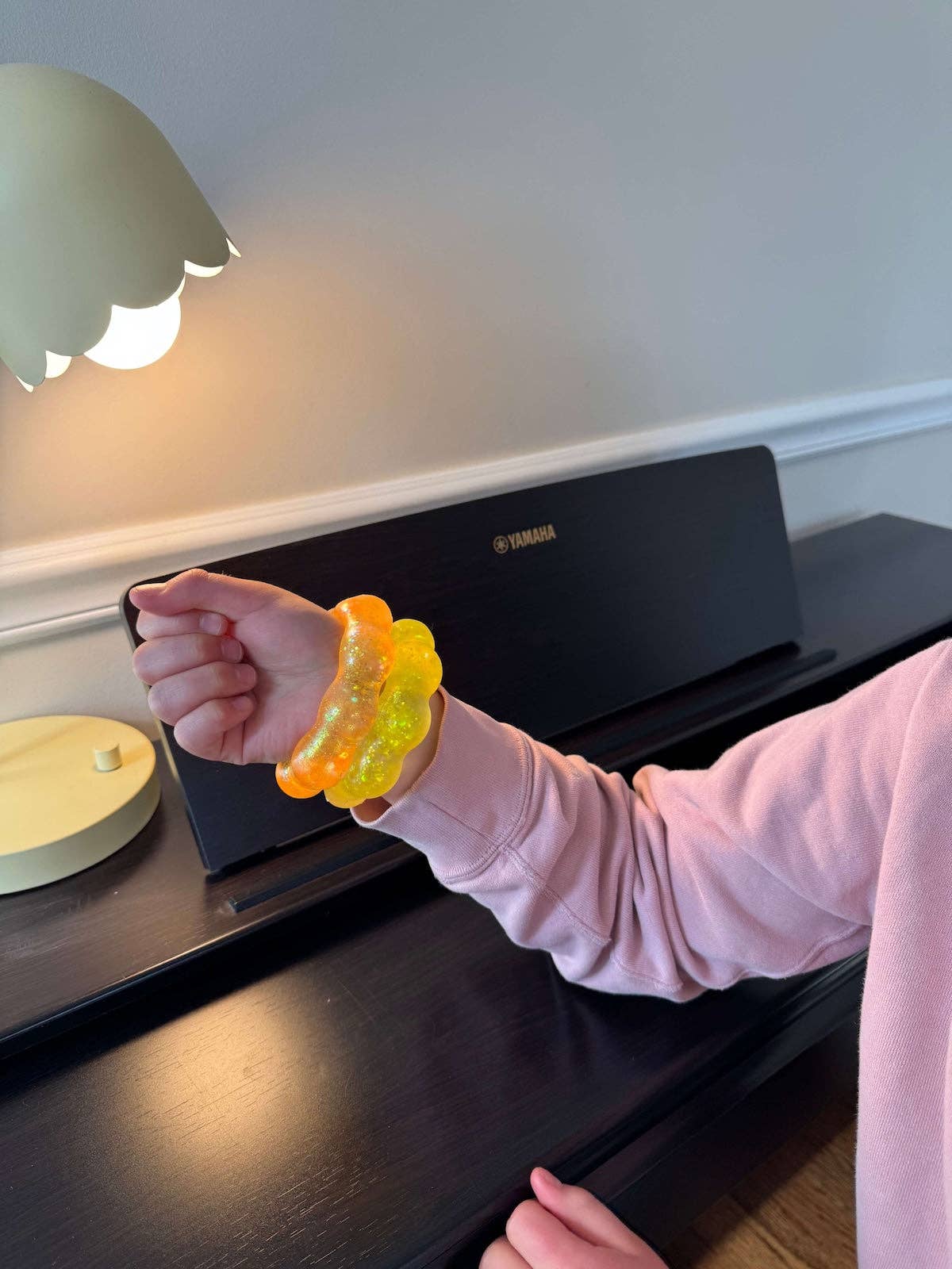 Person wearing a colorful bracelet squish on a piano