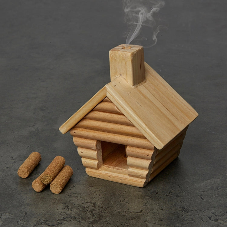 Wooden cabin incense burner with smoke on a dark background