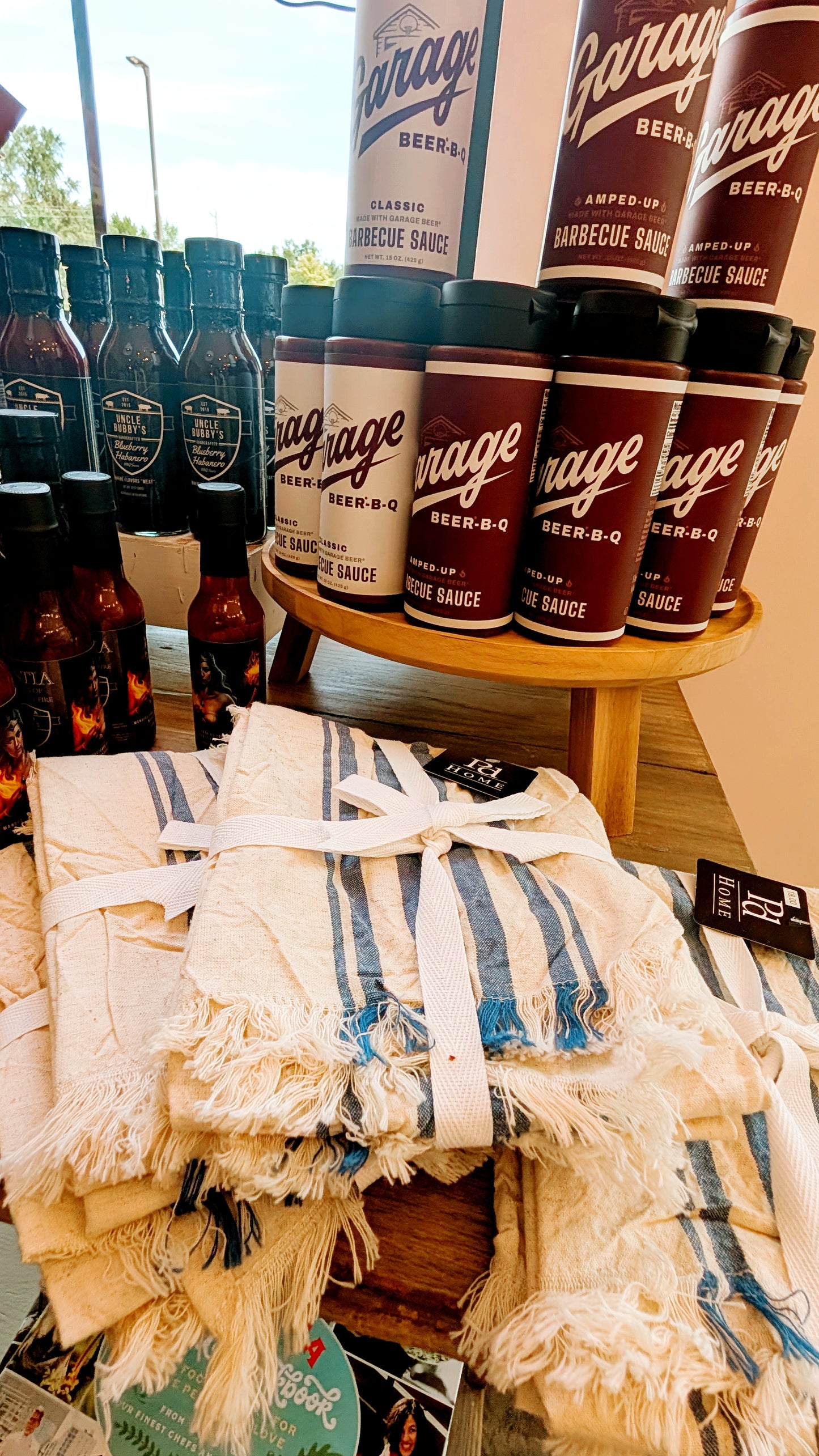 Bottles and cans of 'Garage' beer with a decorative blanket on a table.