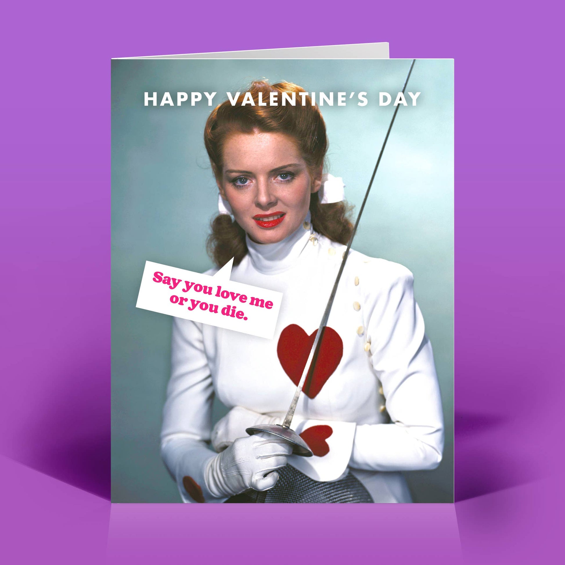 Valentine's Day card with a woman in fencing gear and sword that says "Sy you love me or die" on a purple background.