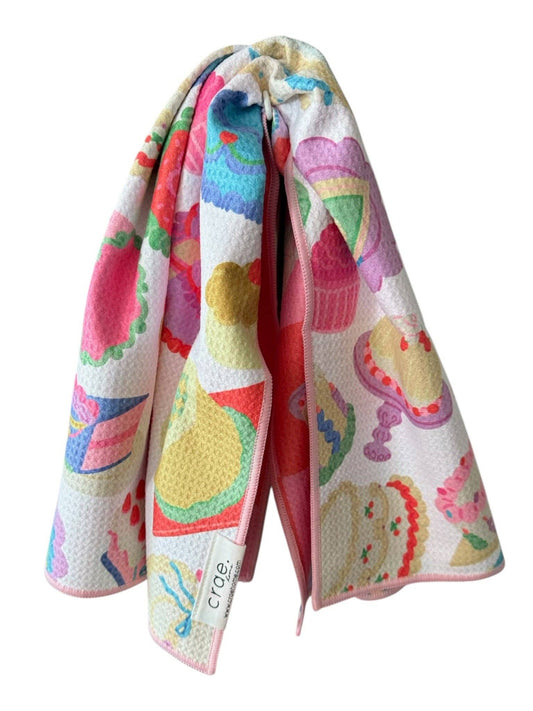 Colorful kitchen towel with cupcake design on a white background