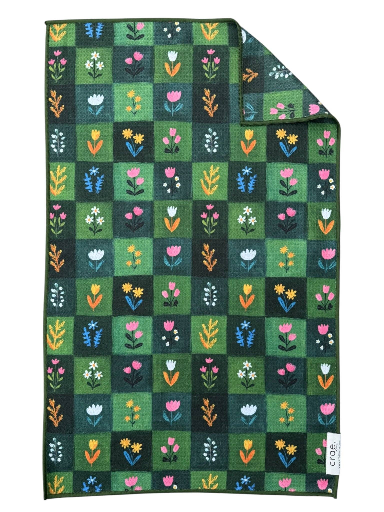 Dark green checkered tea towel with flowers in each square on a white background