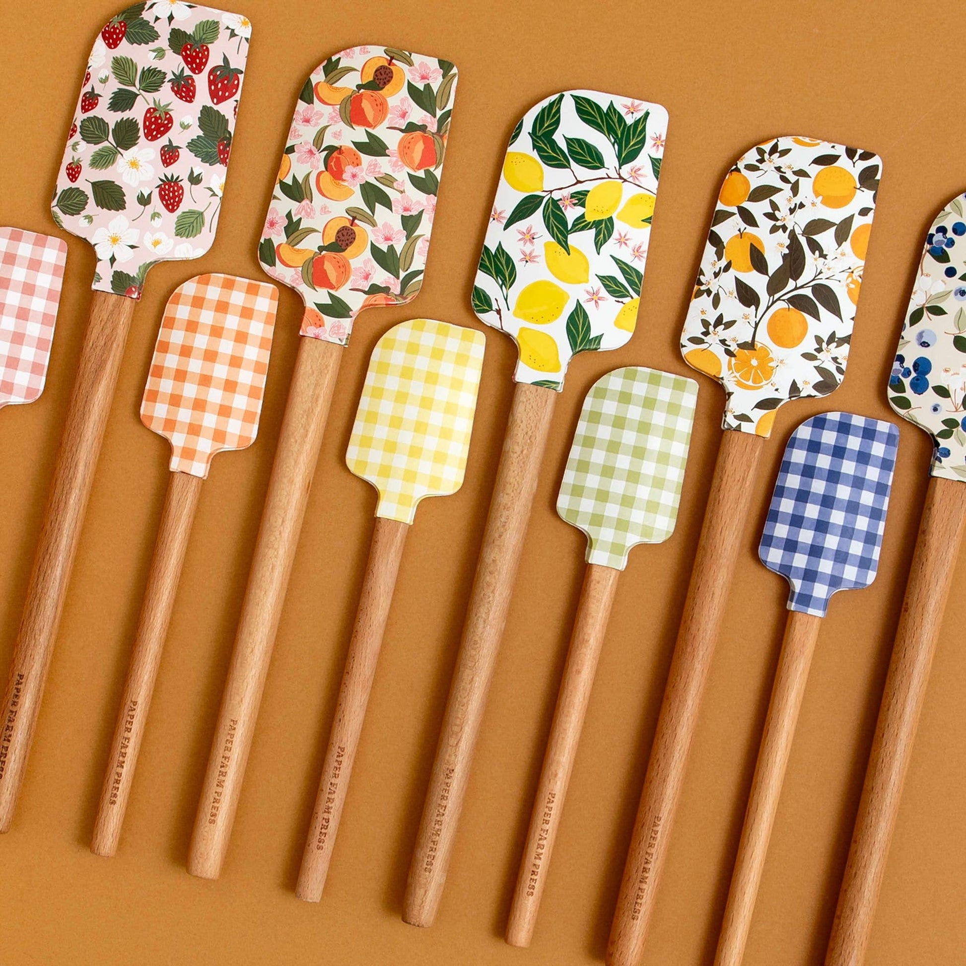 Set of wooden spatulas with patterned heads on a brown background