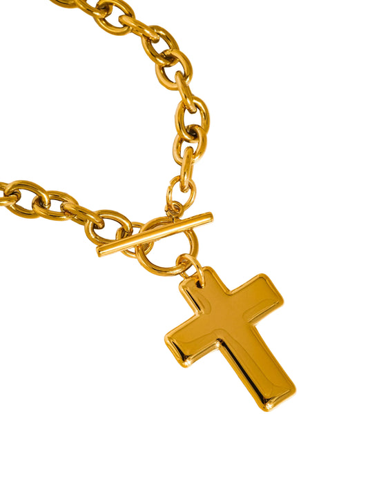 Gold chain bracelet with a gold cross pendant on a white background