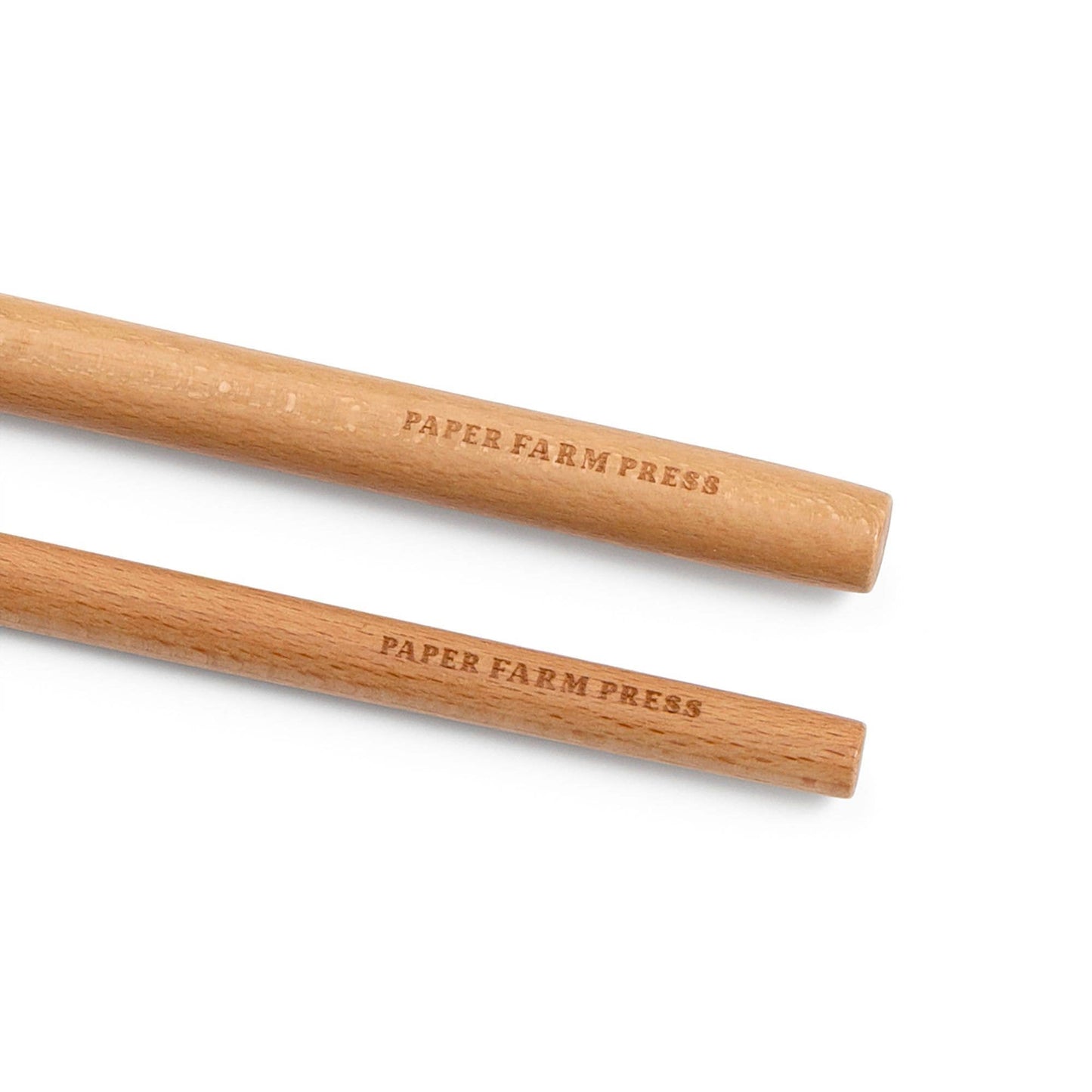 Two wooden pencils with 'Paper Farm Press' branding on a white background
