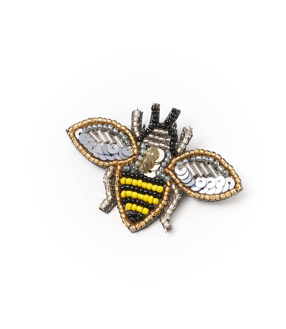Decorative bee pin with beaded details on a white background