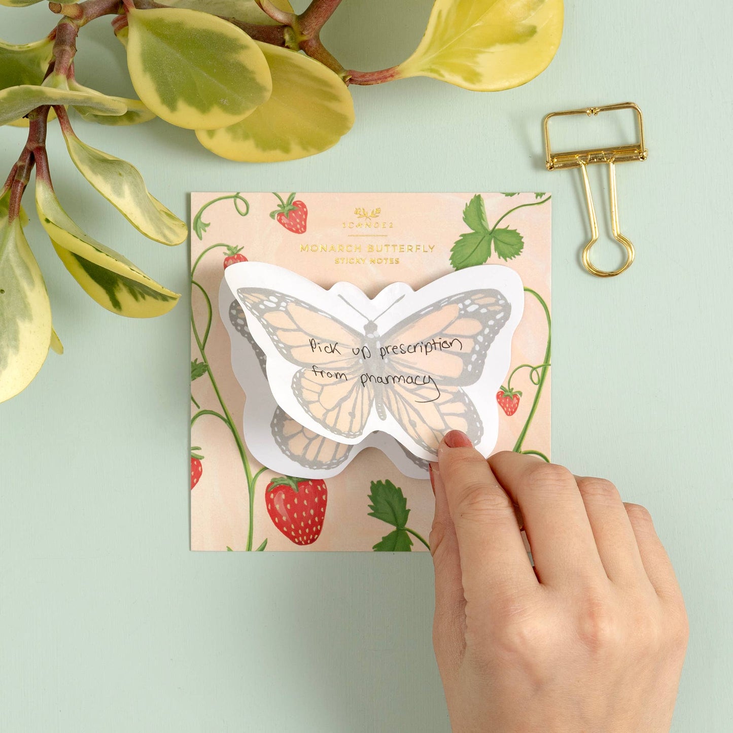 Butterfly-shaped card with strawberry design on a light green background