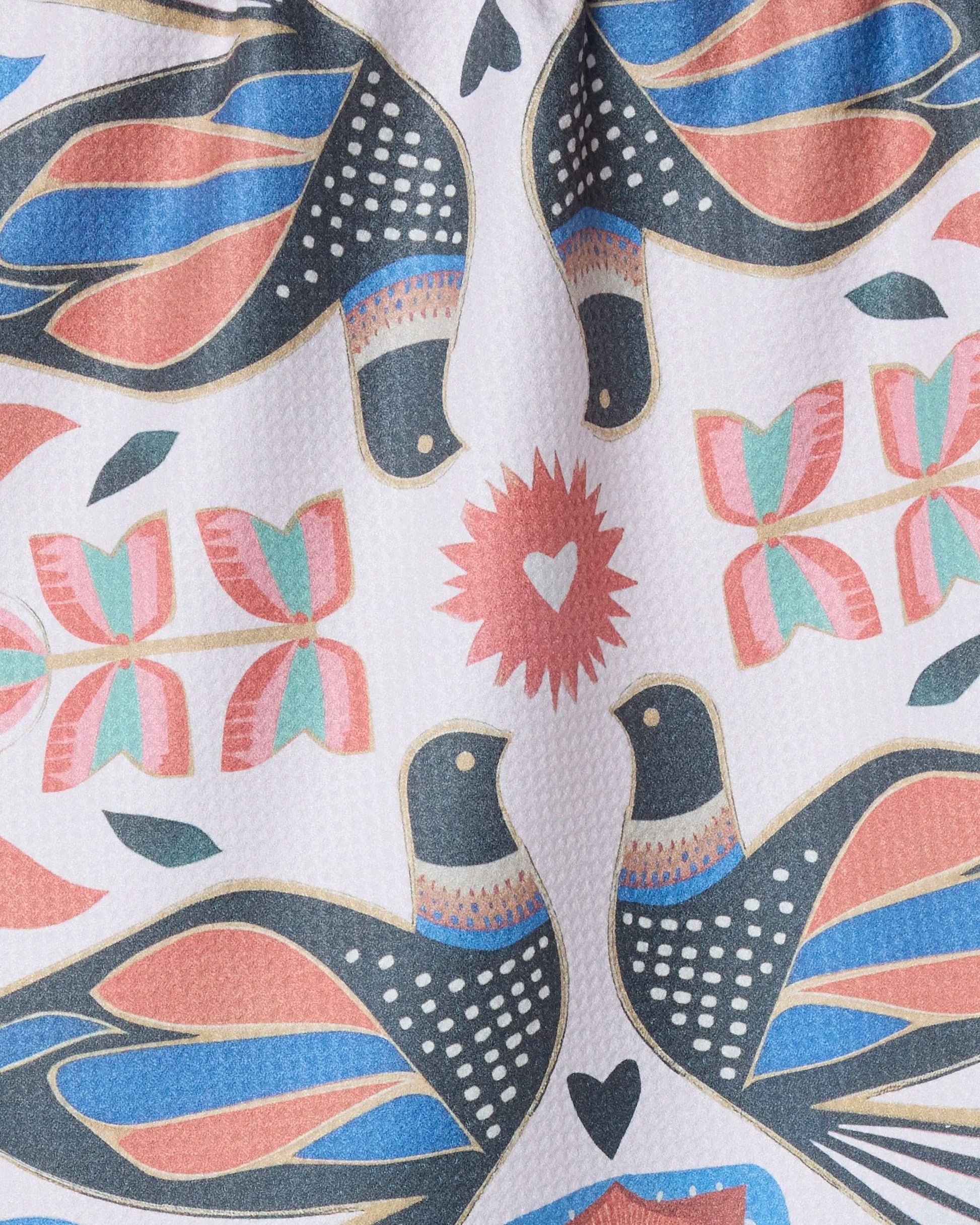 White tea towel with symmetrical pink, blue, gold, and dark grey birds and flowers design 