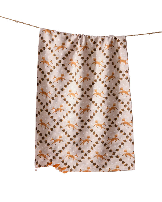Fabric with foxes pattern hanging on a line against a brown background