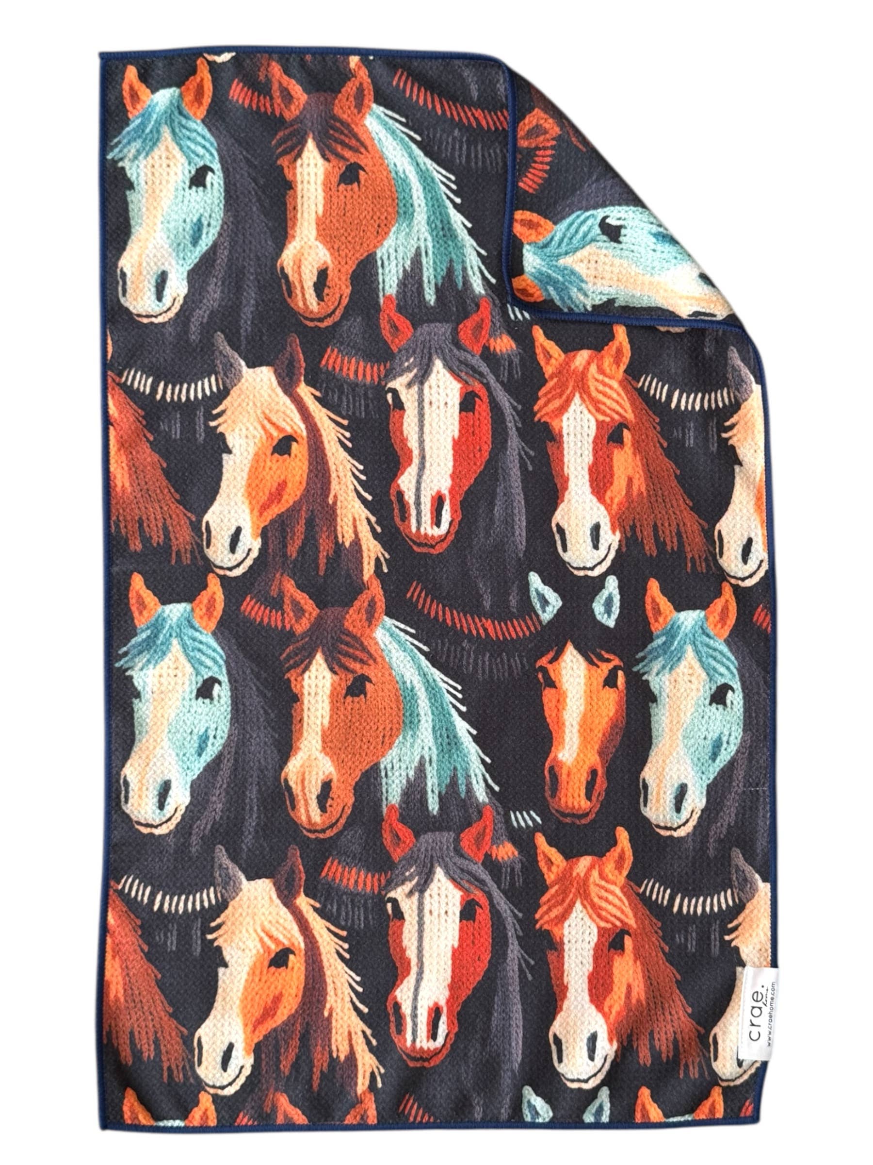 Folded tea towel with colorful horse pattern on a black background