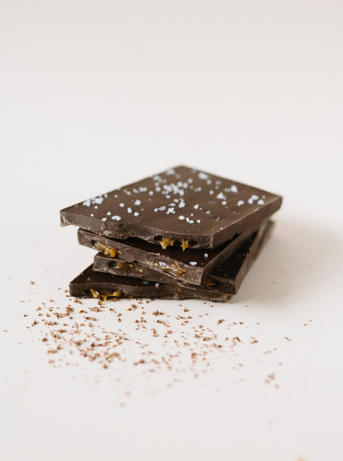 Dark chocolate bar with sea salt on a white surface