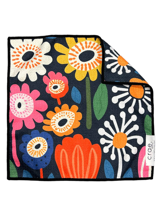 Colorful floral patterned towel with a brand tag on a white background