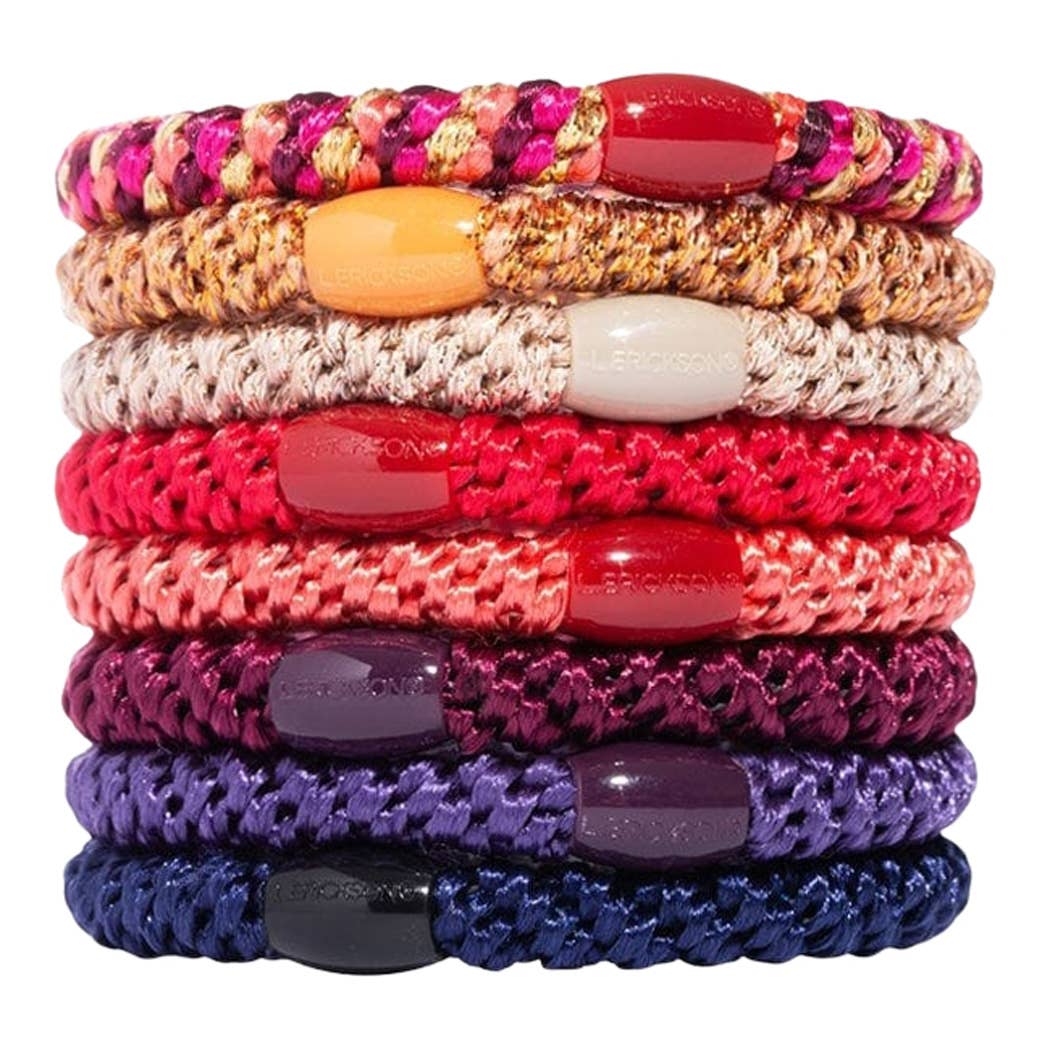 Stack of colorful braided bracelets with various colored beads on a white background