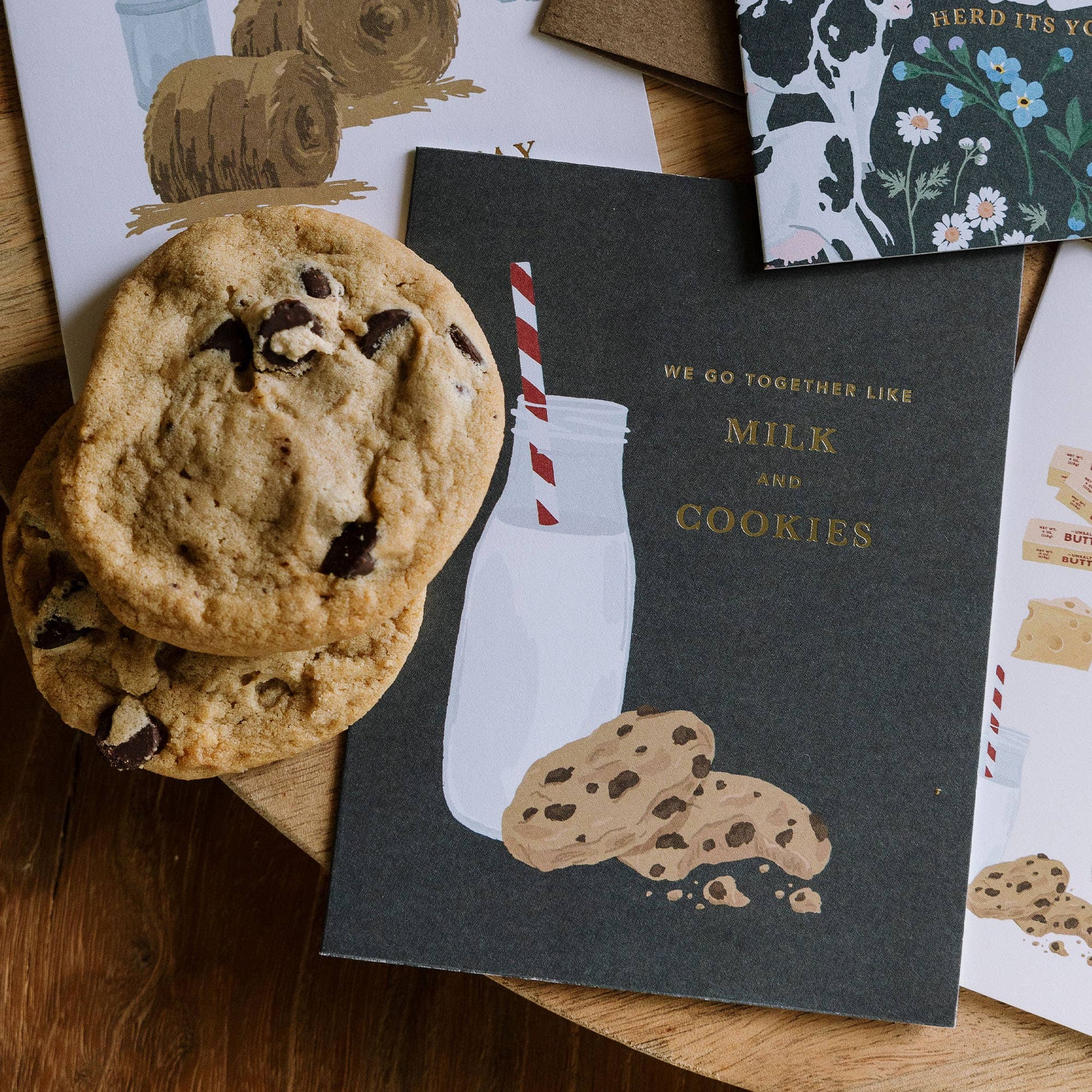 Cookies and a milk bottle illustration on a card with text, surrounded by more cards.