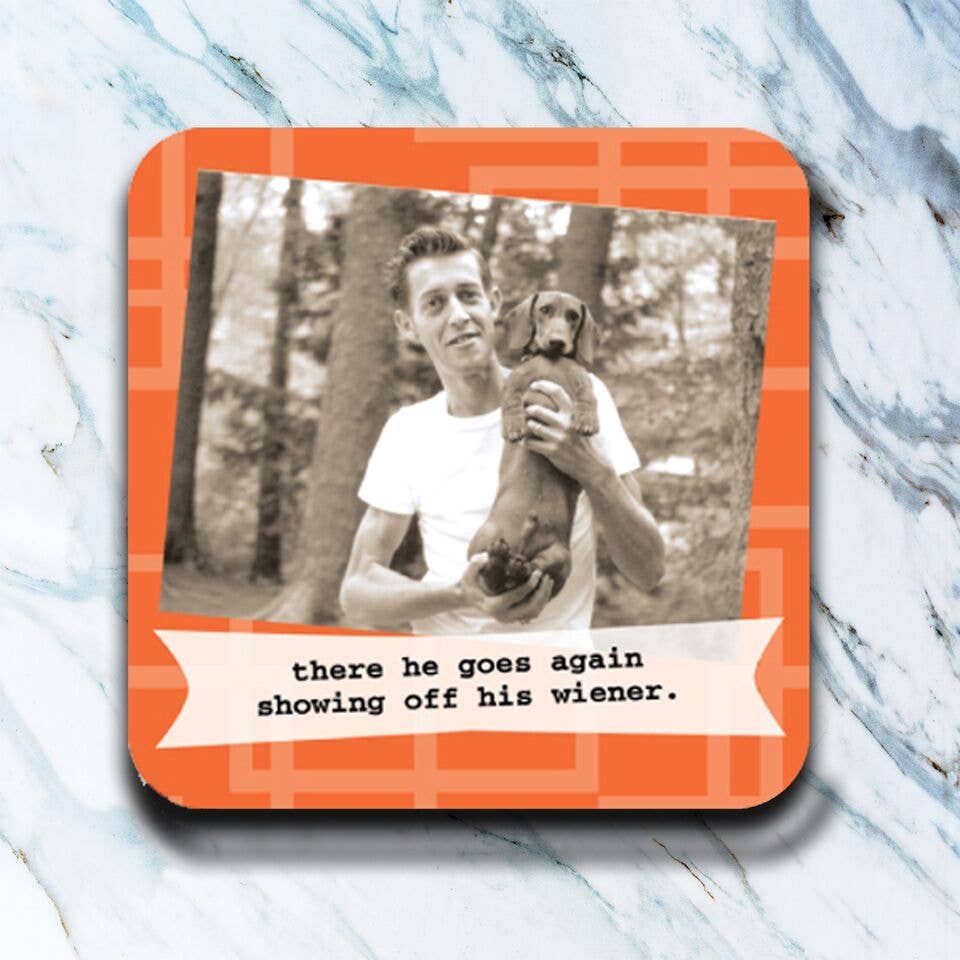Coaster with a black and white photo of a man holding a dog and text on an orange border, placed on a marble surface.