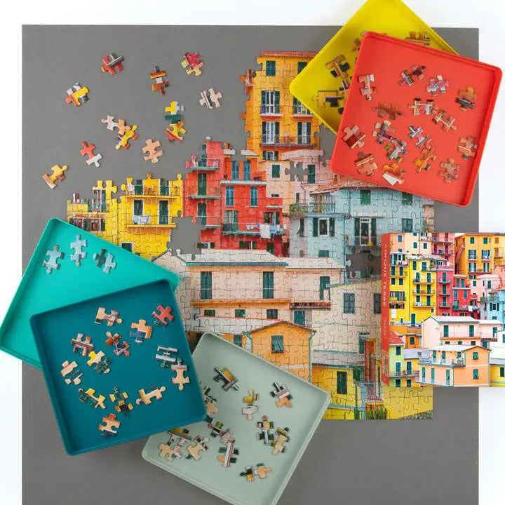 Colorful puzzle pieces on trays with a background of a colorful building collage.
