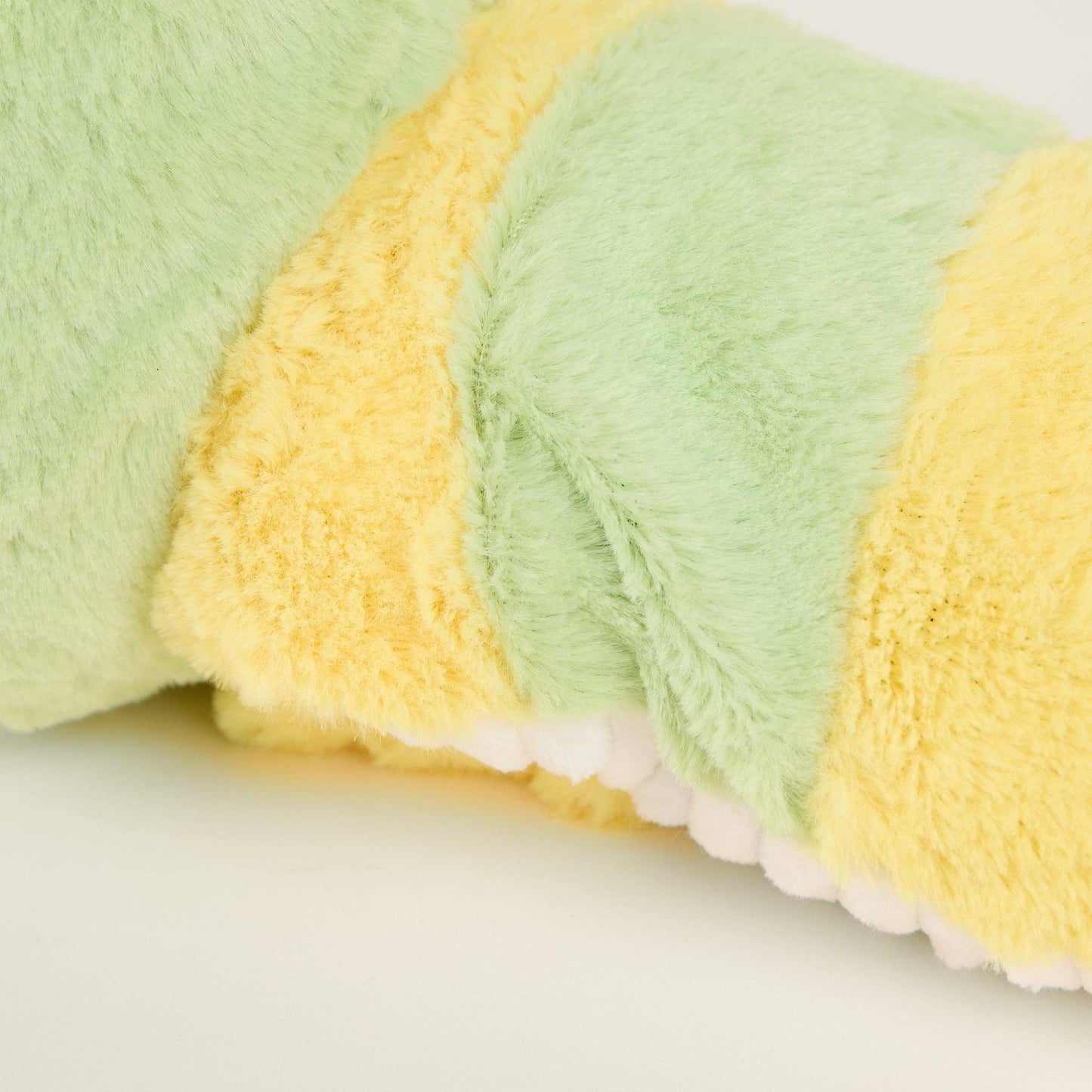 Close-up of a fuzzy green and yellow striped fabric on a white background