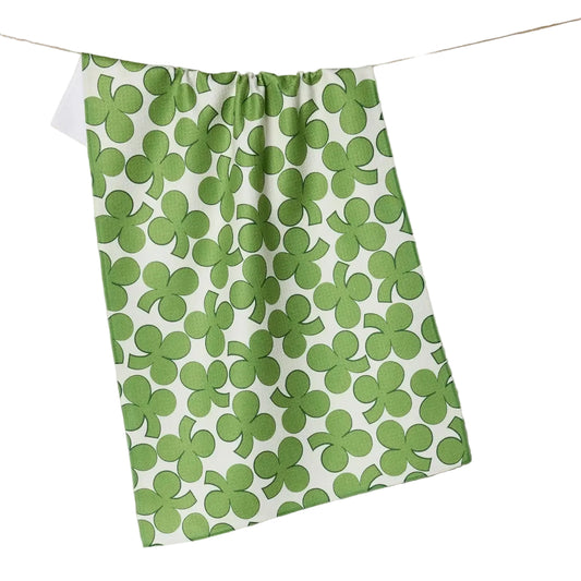 Green shamrock patterned towel hanging on a line against a beige background