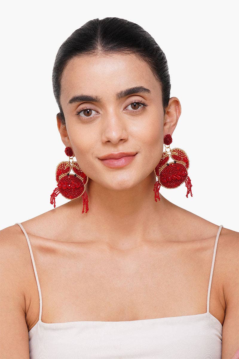 Woman wearing red earrings against a white background