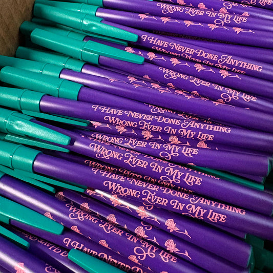 Stack of purple and teal pens with humorous text design.
