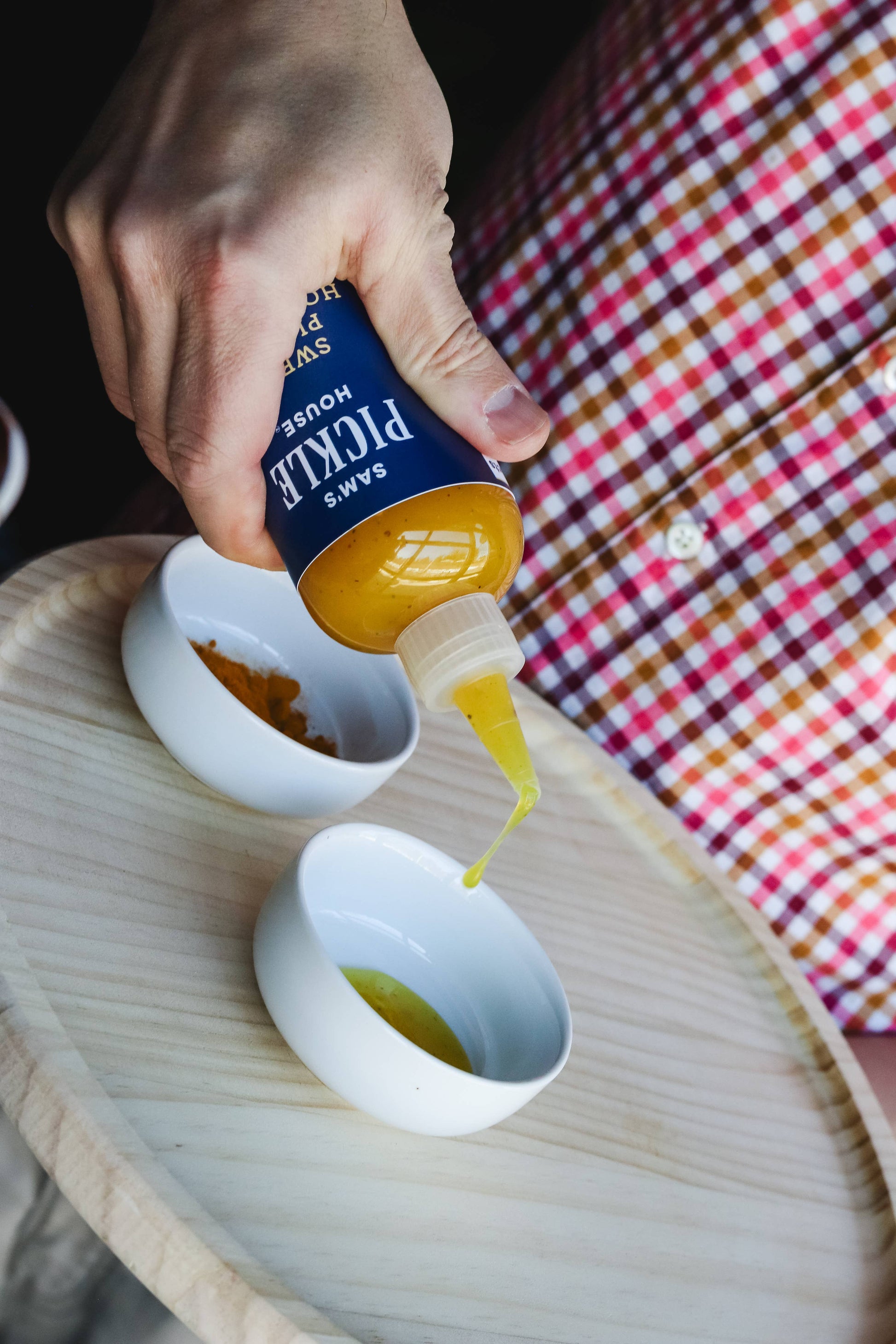 a hand pouring sauce into a bowl