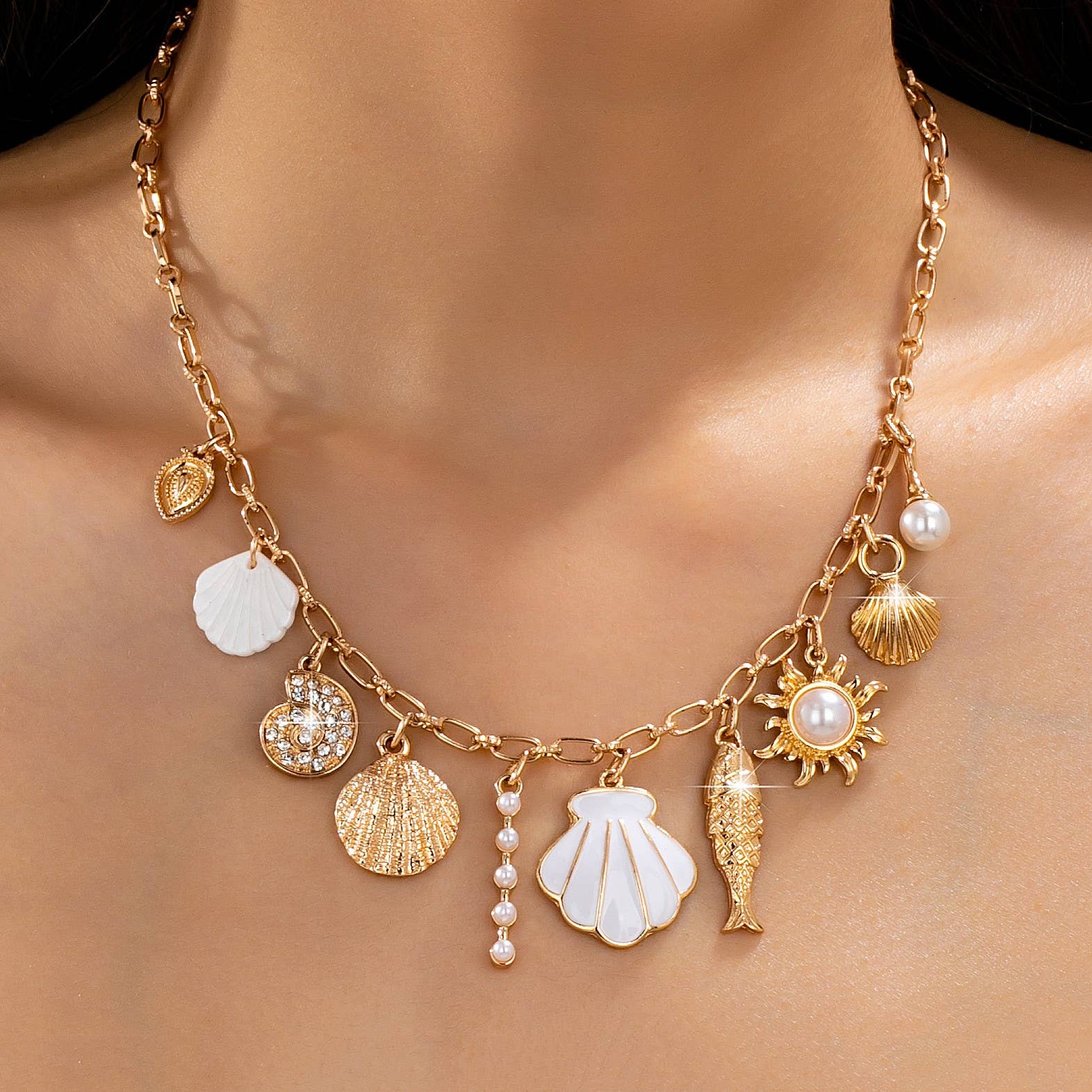 Necklace with various charms including shells, a sun, and a fish on a blurred background