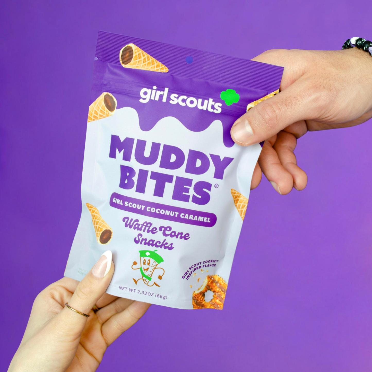 Girl Scouts Muddy Bites waffle cone snacks packaging held by a hand against a purple background