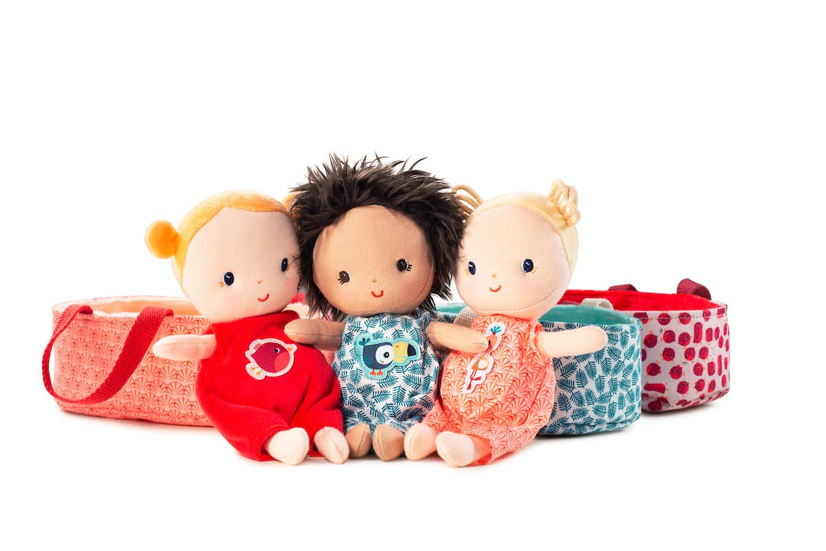 Three dolls with different hairstyles and outfits, sitting on a white background.