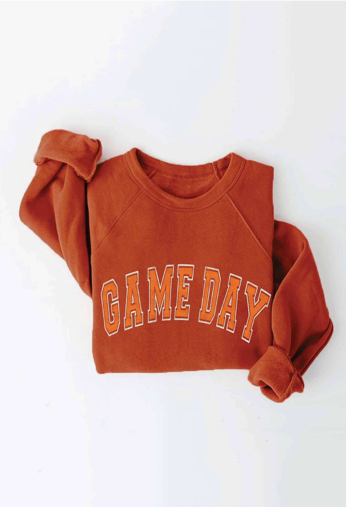 A rust-orange crewneck sweatshirt with 'GAME DAY' printed across the chest in orange varsity-style letters with a white outline, shown folded on a white background.
