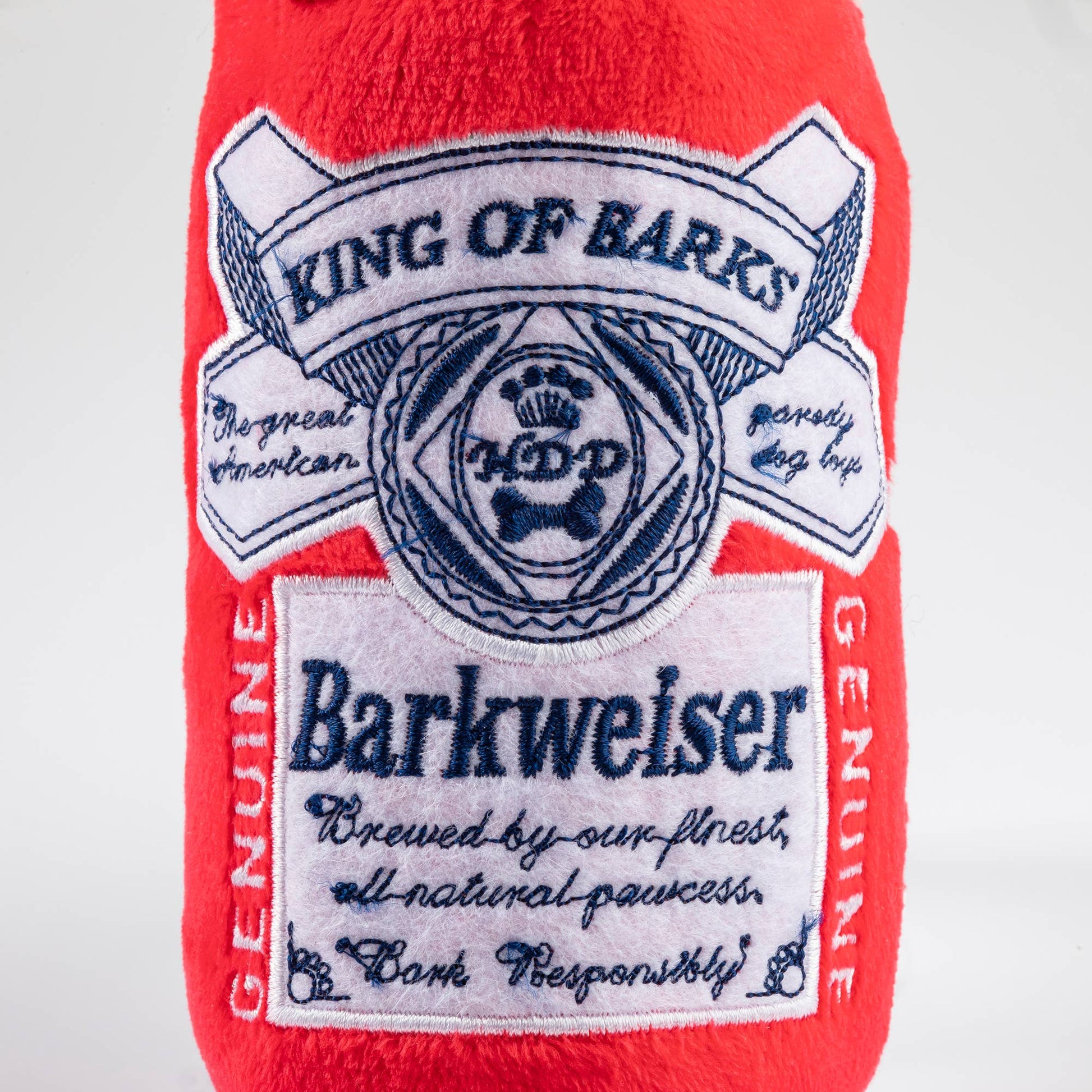 Red plush toy with 'King of Barks' and 'Barkweiser' branding on a white background