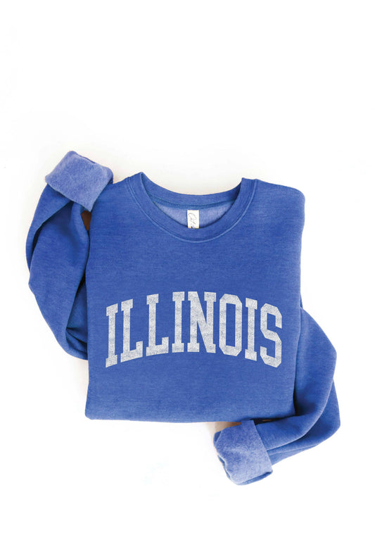 A folded blue crewneck sweatshirt with 'ILLINOIS' printed across the chest in white varsity-style block letters, shown on a plain white background.
