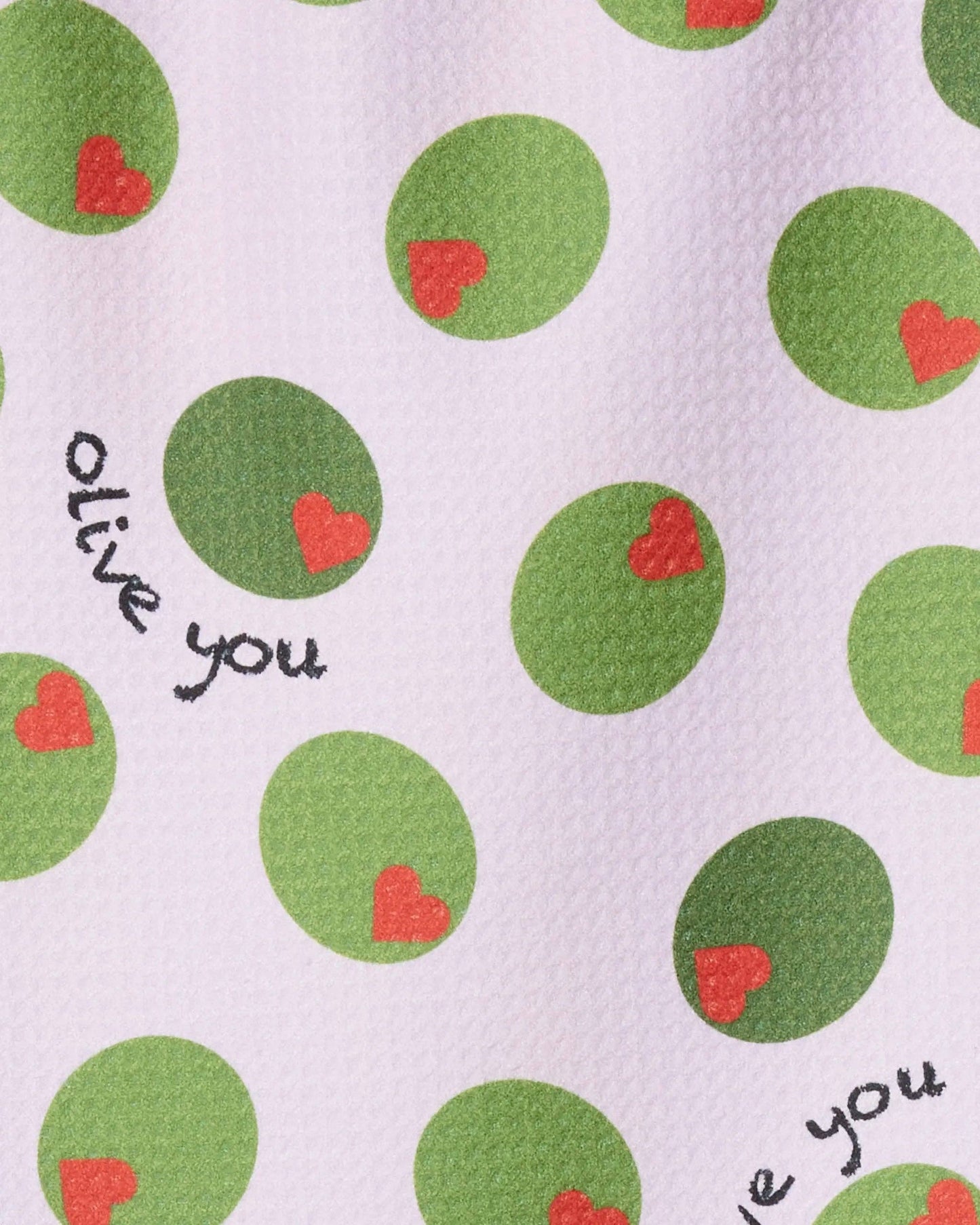 White tea towel with green olives with red heart pimentos pattern and text that reads "Olive You"