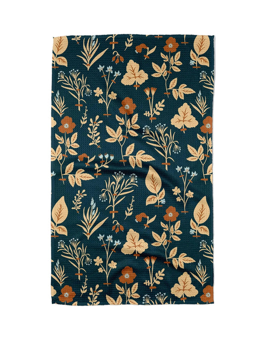 Floral patterned fabric with leaves and flowers on a dark blue background