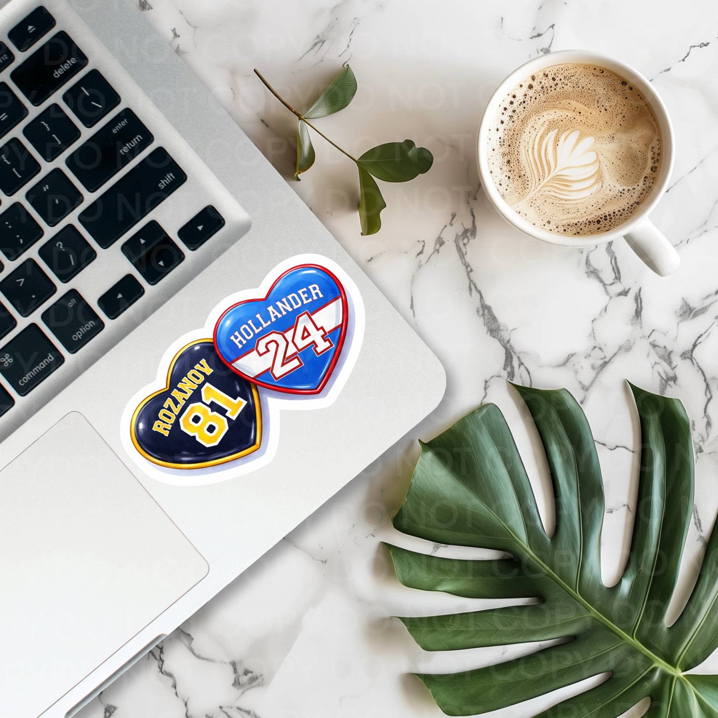 Laptop with Hollander 24 stickers on a marble surface with a cup of coffee and leaves.