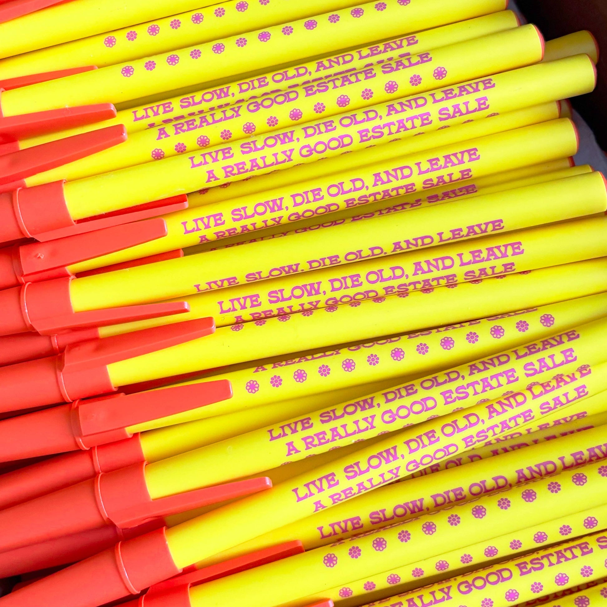 Stack of yellow and red pens with text on a white background