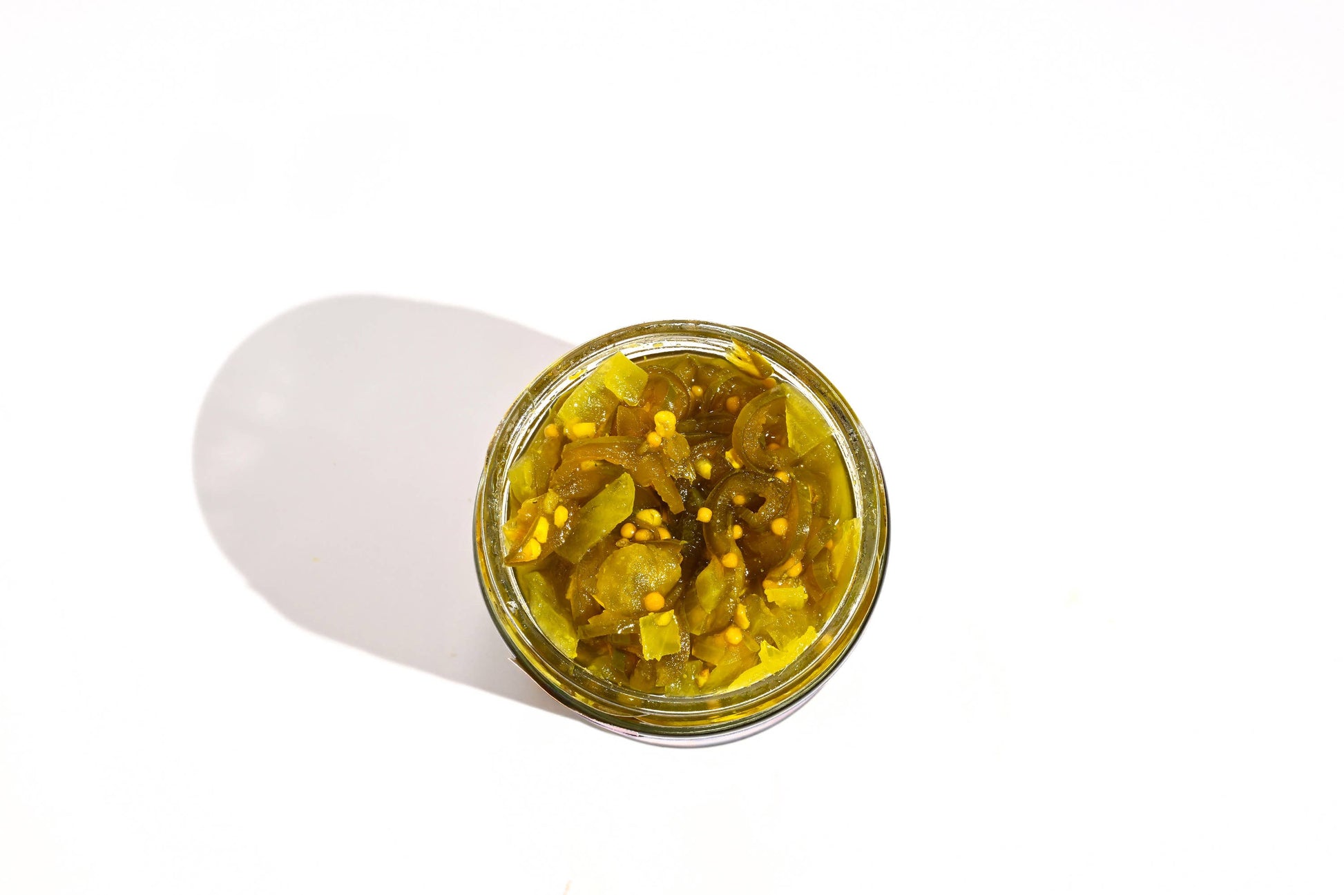 Jar of yellow contents with a white lid on a white background