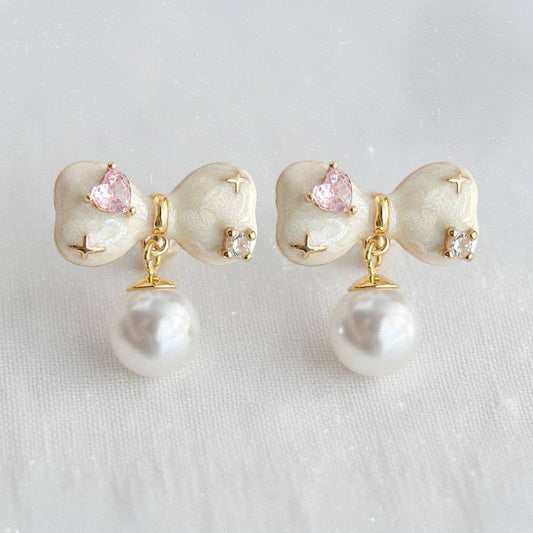 Pair of earrings with pearls and pink gemstones on a light background