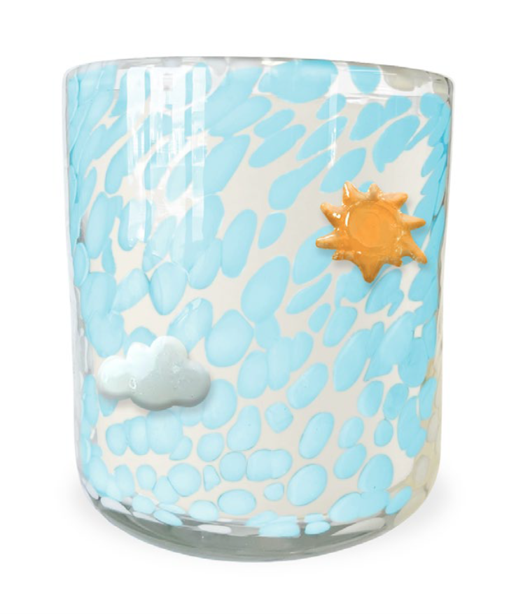 Glass tumbler with blue abstract design, sun, and cloud decorations on a white background