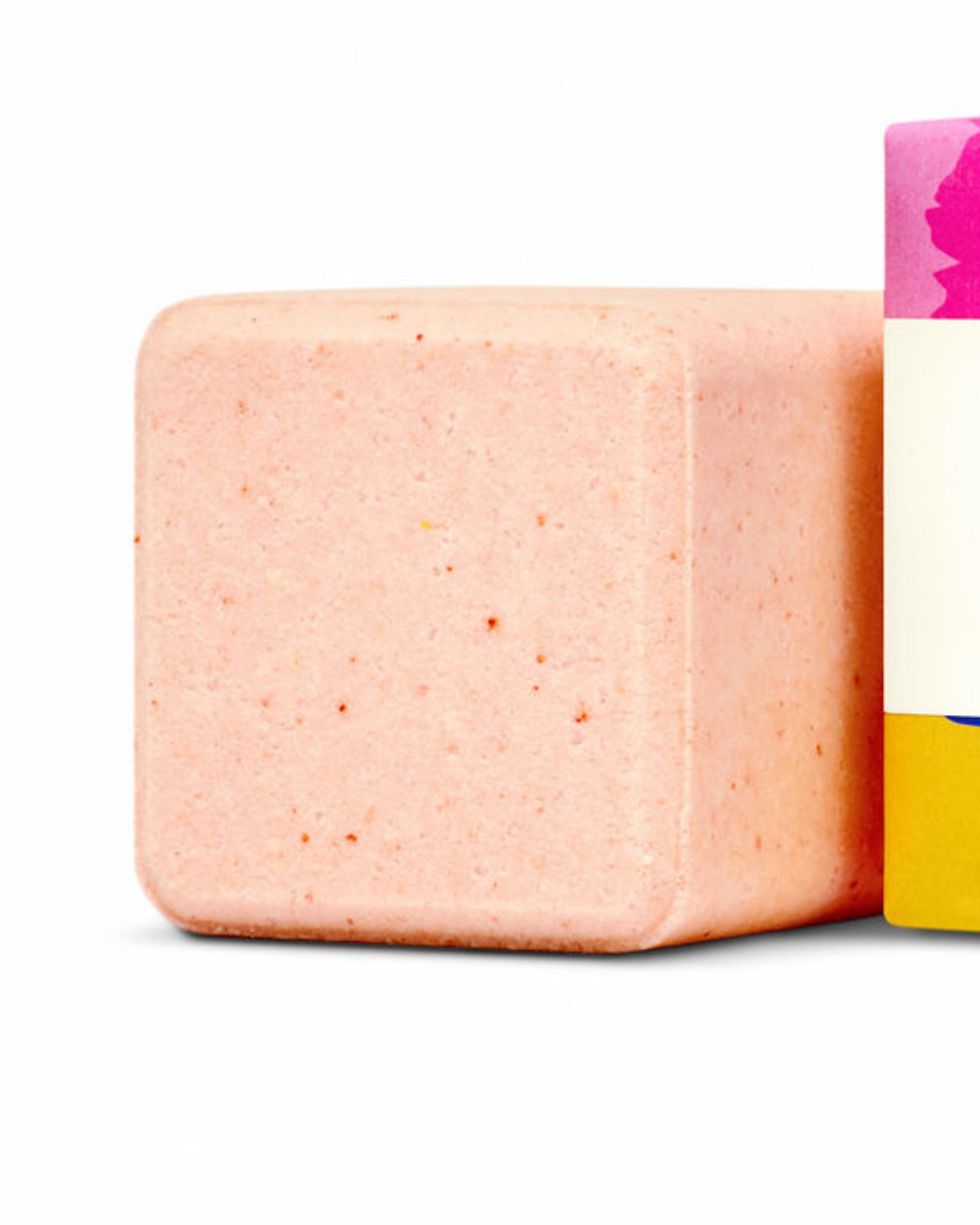 Pink bath bomb with a colorful label on a white background