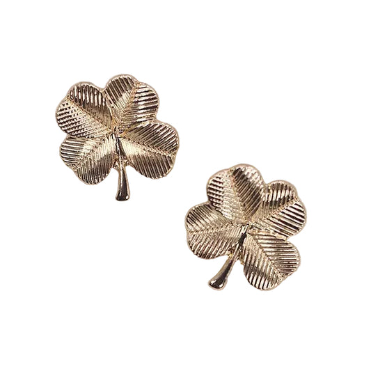 Two gold, four leaf clover shaped stud earrings on a white background