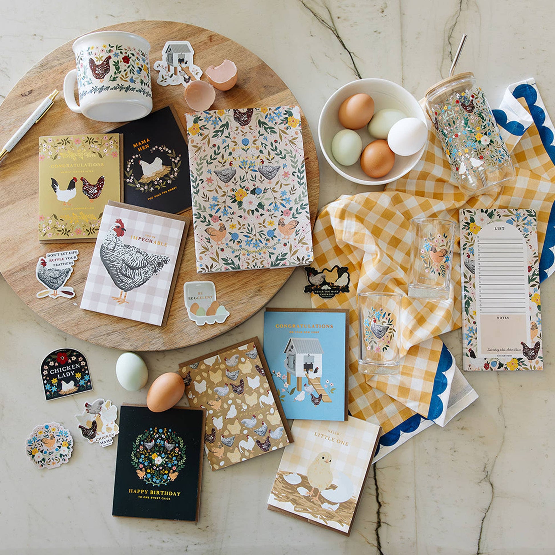 Collection of stationery items with farm-themed designs on a marble surface.
